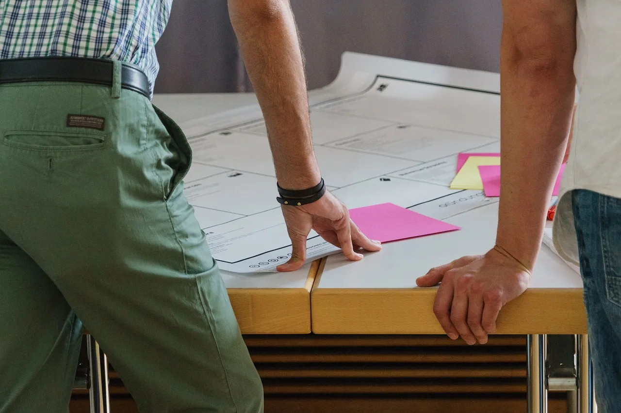 Des professionnels du nettoyage et du traitement des façades et des toitures sont réunis autour du plan d'une maison du Médoc en Gironde.