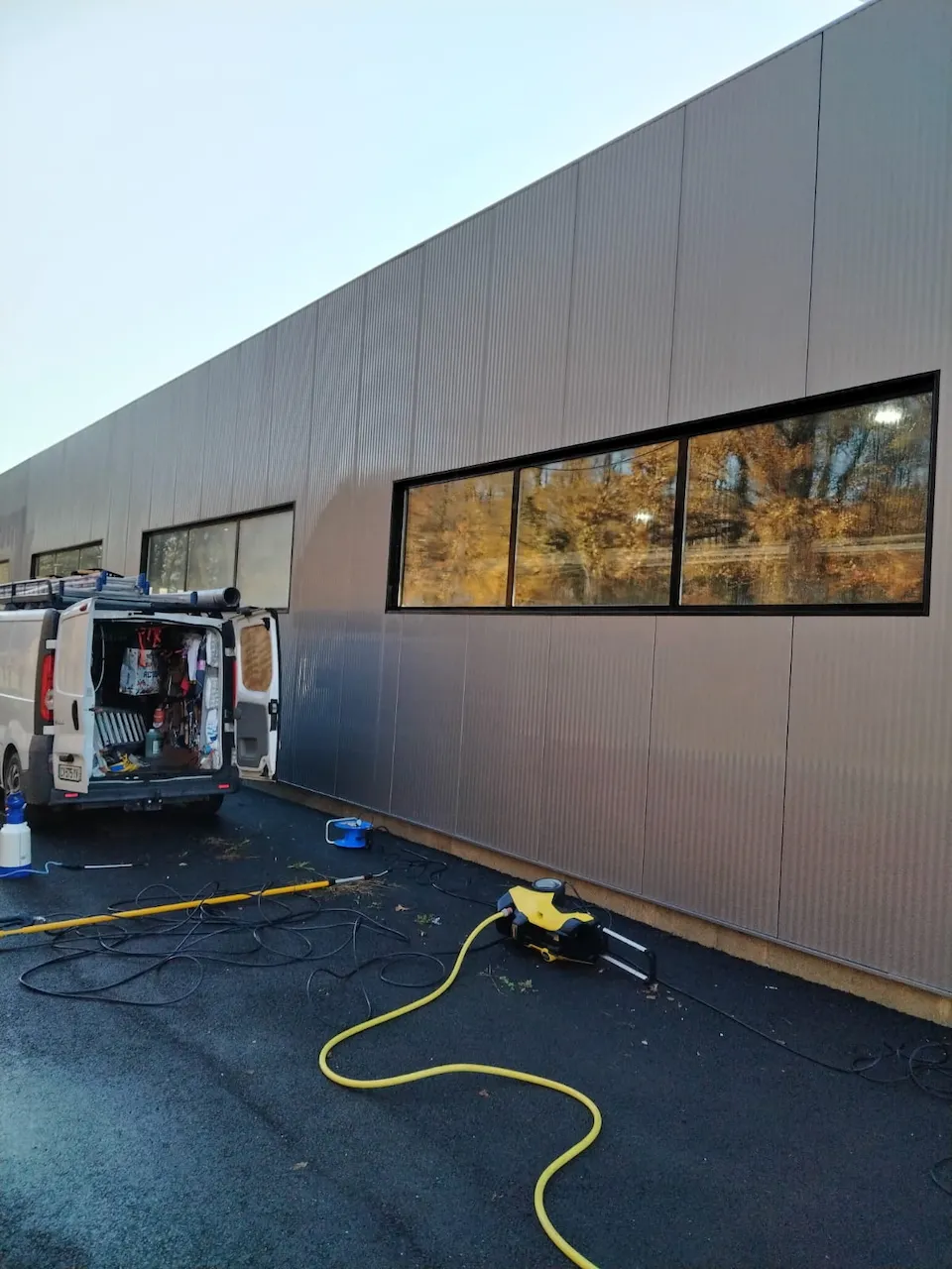 Nettoyage de a façade en bardage métallique d'un bâtiment industriel .
